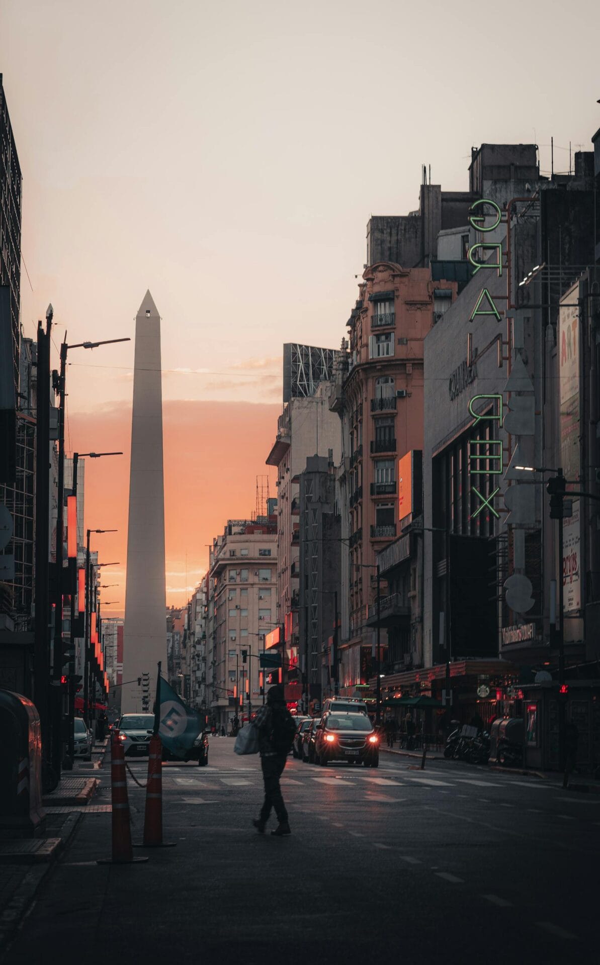 A person walking down a street at sunset